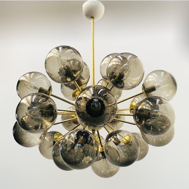Italian oval shaped sputnik chandelier with 24 smoky Murano glass globes carefully hand blown with bubbles inside the...