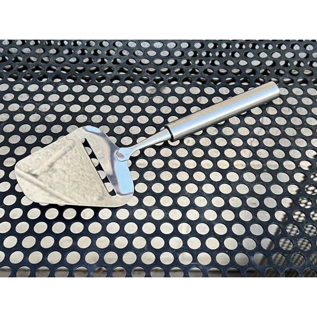 Vintage 1990's Stelton stainless steel cheese plane. Measurements: 9"L x 2.9"W x 0.7"H
