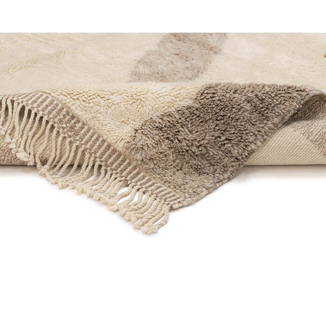 Stunning hand-knotted rug with an abstract motif in contrasting shades of Ivory and Misty Taupe, creating a bold, artistic...