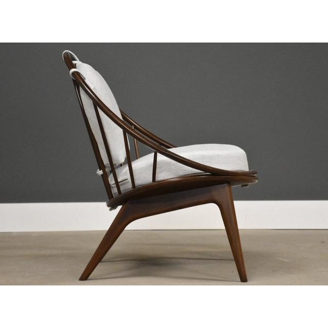 A mid century modern walnut hoop chair designed by Ib Kofod Larsen for Selig newly reupholstered in off white tweed...