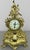 An elegant Vintage French brass clock with an elaborate decorative case, ornate scrolling forms, openwork detailing,...