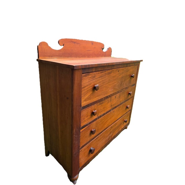 Steeped in the understated sophistication of early 19th-century America, this circa 1830s Empire chest of drawers tells a...