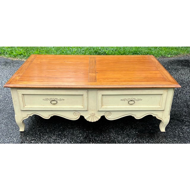 Solid maple coffee table by Ethan Allen from their Country French Collection. Honey toned top with antique ivory painted...
