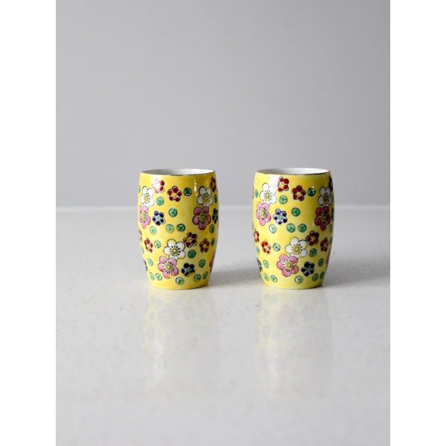 This mid-century pair of Viking hand-painted pottery vases features a sunny yellow ground accented with floral motifs in...