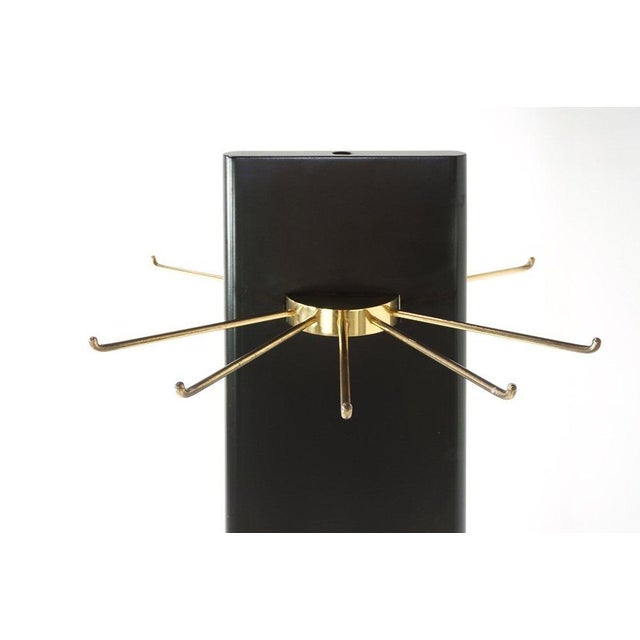 Swivel coat rack in black lacquered wood and brass.