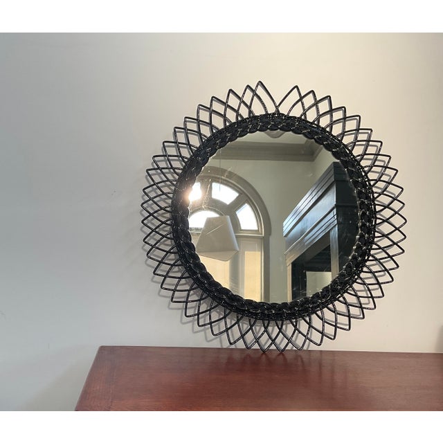 Bring organic texture and mid-century boho charm to your wall with this striking round wicker mirror. Featuring an eye-...