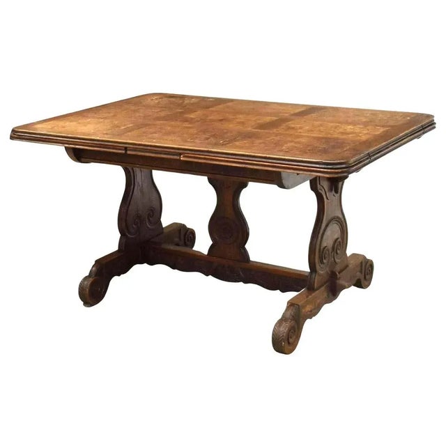 Antique French oak and elm extension table, late 19th c. The table features parquetry tabletop with draw leaves, carved...