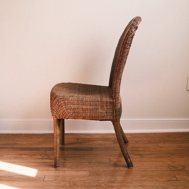 A beautifully textured vintage wicker side chair with a tall, gently curved back, woven seat, and slender rattan legs...