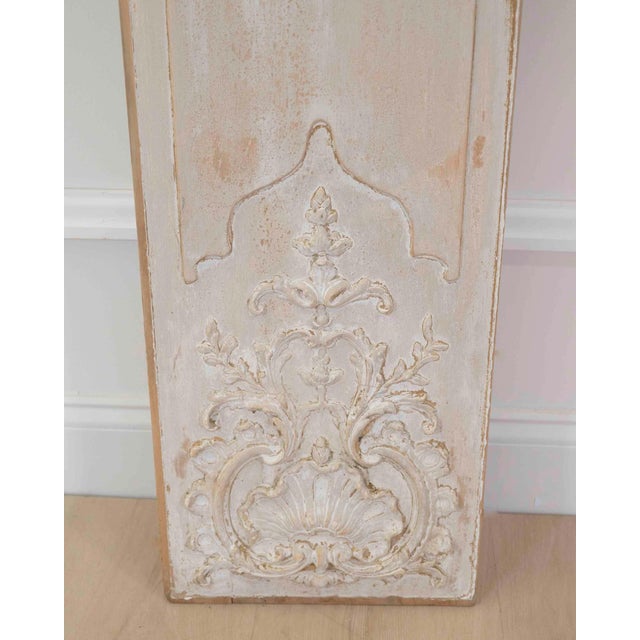 An elegant pair of antique French boiserie panels featuring beautifully carved Rococo-inspired ornamentation and a softly...