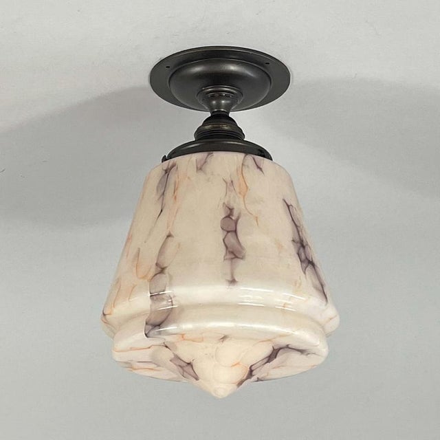 This Art Deco flush mount has been designed and manufactured in Germany in the 1930s. The light features a tapered marbled...