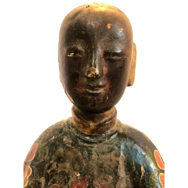 This sculpture is an antique Chinese lacquered and polychrome-painted wood figure dating from late in the Qing Dynasty...