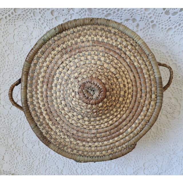 A large handwoven lidded basket with a greenish tint to the fiber. It measures 16 ½” diameter x 10” h x 6 ½” base. Lovely...