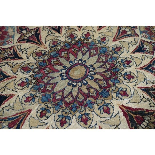 This finely woven SE Persian city carpet shows a shaped and indented ecru-beige semi-open field centered by an octogramme...