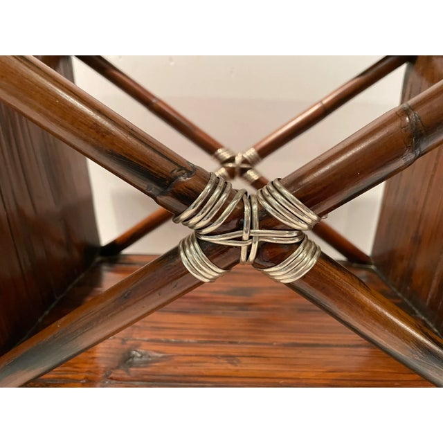 This is a very handsome wooden magazine stand with an X motif that is wrapped in silver banding. The feet of the stand are...