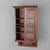 A 20th-century hanging curio cabinet, crafted from walnut wood. This display piece features a single glass-front door,...
