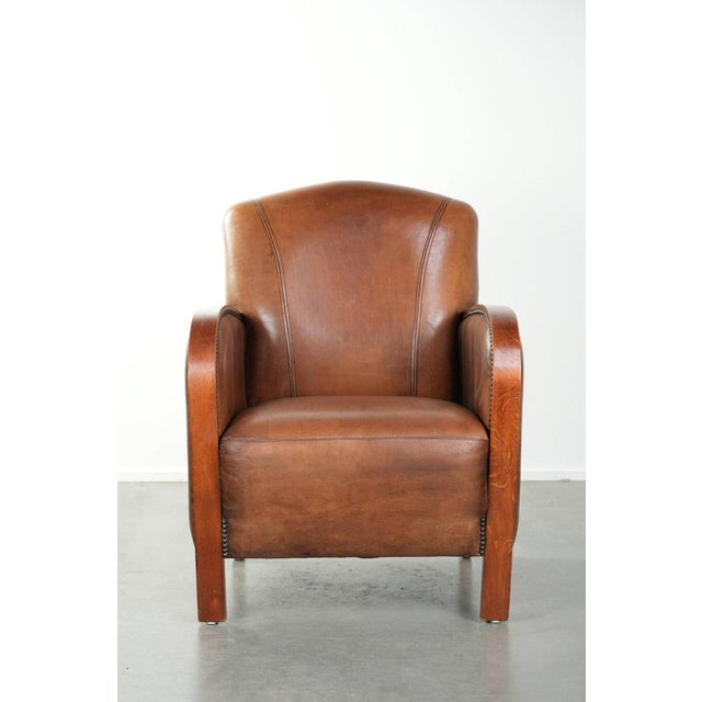 Beautiful Art Deco style sheepskin armchair with wooden armrests, excellent seating comfort, and a characterful...