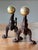 A striking pair of 19th century English brass and cast iron andirons, beautifully crafted and rich with the quiet drama of...