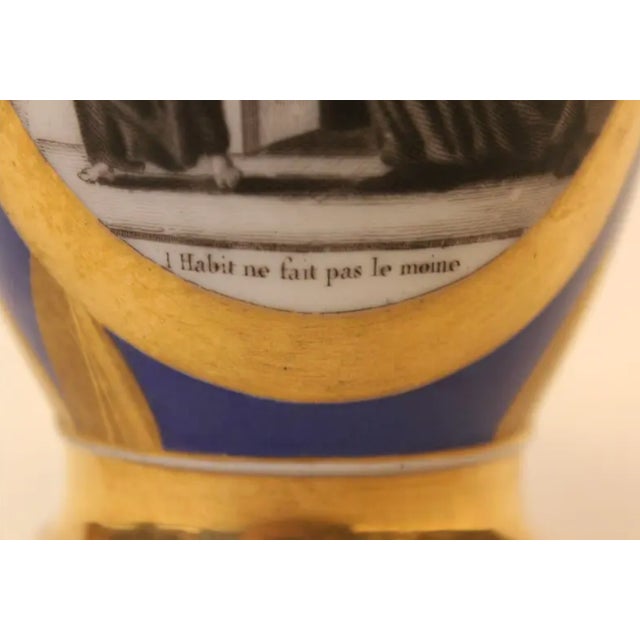 Stunning gold and cobalt blue ewer has a subtle pattern of leaves and scalloped edges. The charming grisaille image...