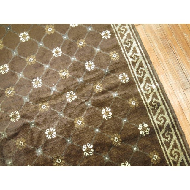 A vintage midcentury Turkish rug having a contemporary design on a predominant chocolate brown background. Measures: 6'9''...