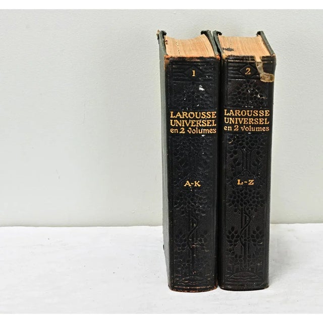 A two volume set of French encyclopedic dictionaries by Claude Augé are leather bound with gold lettering stating the...