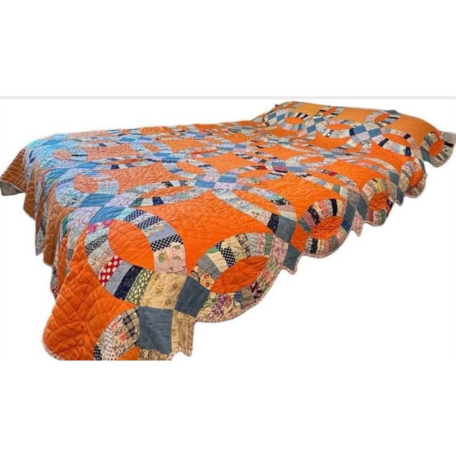 A striking American Double Wedding Ring patchwork quilt dating to the 1930s–1940s, featuring a vibrant solid orange...
