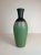 This large floor vase in Art Deco style has a mate green color with metal threads leading up to a black top. Good vintage...