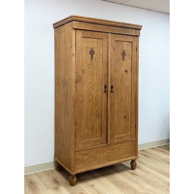 This antique European wardrobe showcases the warm, natural grain of solid pine, that highlights the wood's authentic...