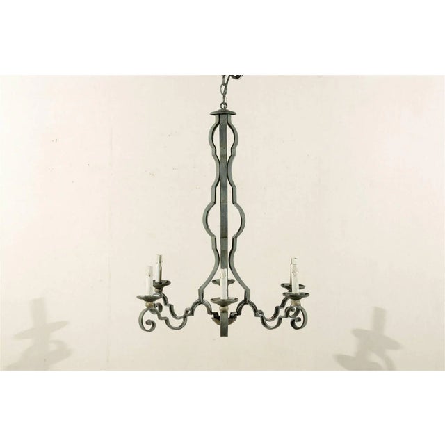A French mid-20th century painted iron six-light chandelier with scroll arms. This French painted iron chandelier has been...
