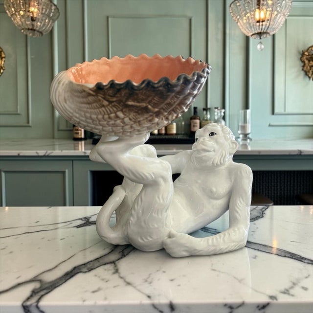 Whimsical vintage Italian ceramic centerpiece featuring a reclining monkey supporting a large shell-form bowl overhead....