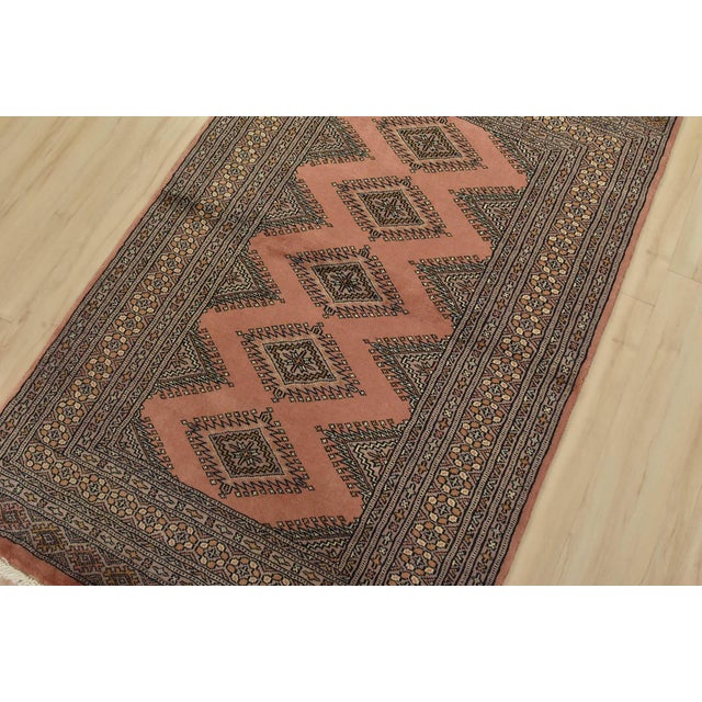 A tribal Bokhara Jaldar rug hand-knotted with fine wool on a cotton foundation. This rug features geometric medallions set...