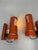 A pair of adjustable wall lamps with a distinct 1970s space-age design, featuring a cylindrical structure in orange...