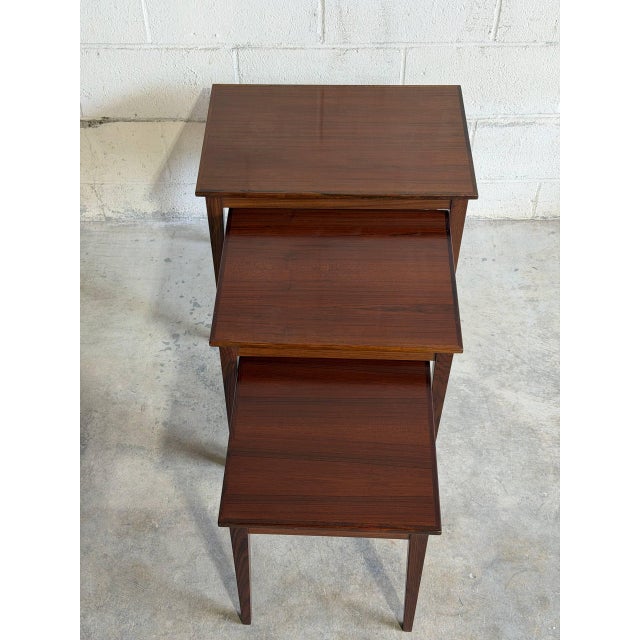 Elegant set of three Danish Modern nesting tables crafted in richly grained rosewood in Denmark during the 1960s....