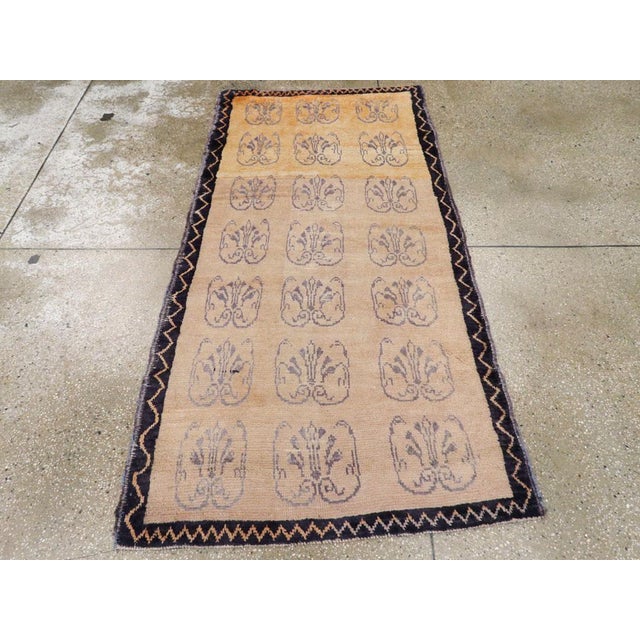 A vintage Turkish Konya rug. An abrashed old ivory ground displays three columns of seven blue openwork palmettes and thin...
