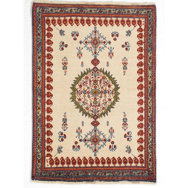 Vintage Persian hand-knotted Lori wool rug featuring an ivory field with a central floral medallion and delicate geometric...