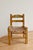 Antique wooden child's chair, hand-decorated with colorful floral motifs on an ochre background, with a woven straw seat....