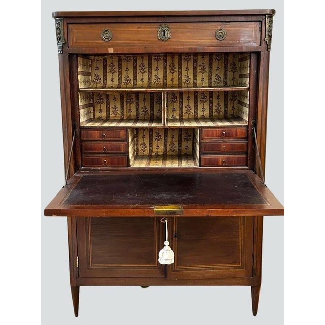 Elegant French Louis XVI style secretary desk featuring beautiful bookmatched veneer on the fall-front writing surface and...
