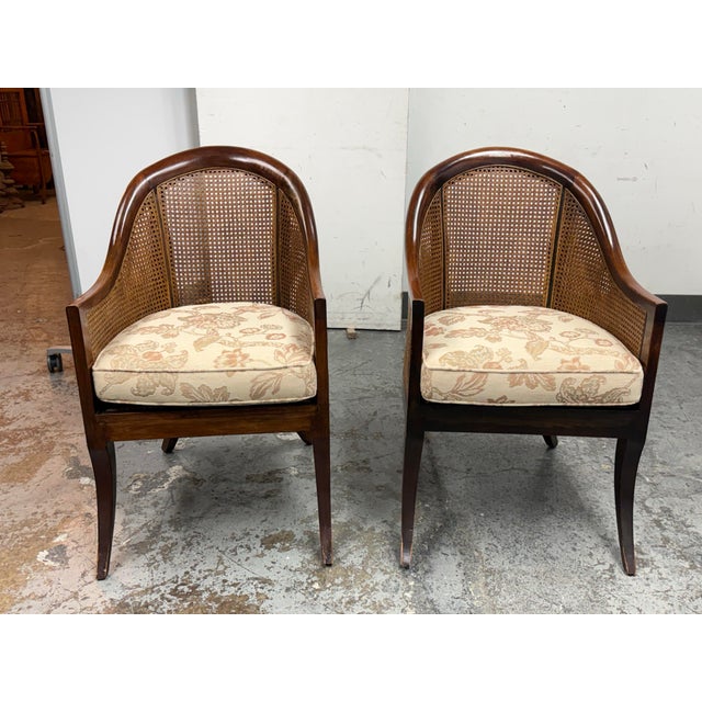 Design Plus Gallery presents a Pair of Mahogany Bergère Chairs in Regency Styling. The chairs have caned backs and sides...