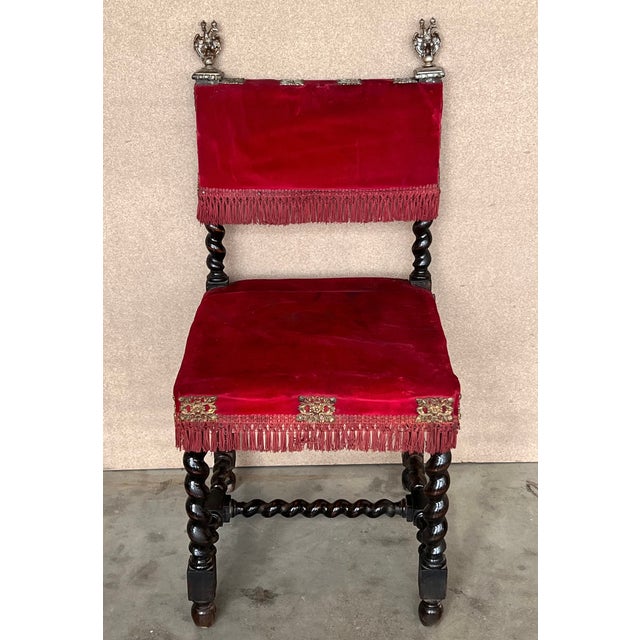 A set of 6 Spanish chairs with walnut structure, hand carved decoration and red velvet seat. The pieces have a bronze...