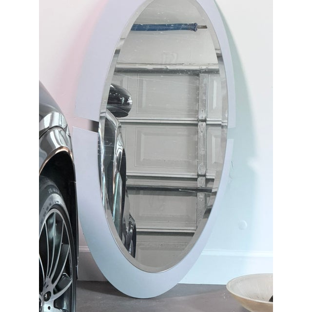 A large landscape-oriented oval wall mirror with a sleek dark matte frame. Clean, versatile design suits a variety of...
