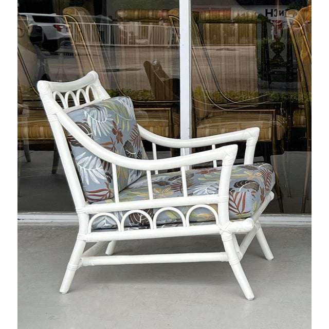 A mid century rattan Chair and ottoman by Willow and Reed. White enameled rattan frame with New embroidered upholstery....