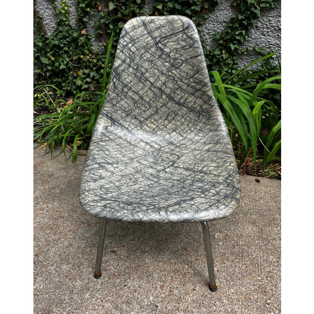 1960s fiberglass chair with on swivel frame. The unique shell features a cream- white colors with black threads melted...