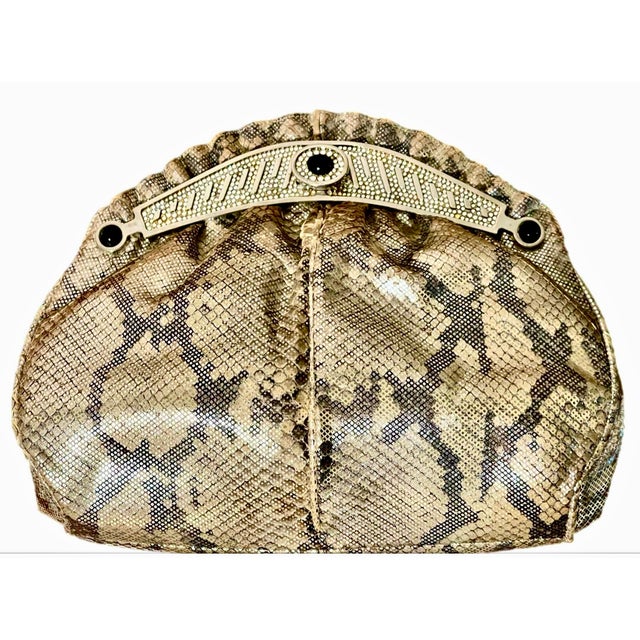 Showstopper metallic, reticulated python clutch in tones of gunmetal and silver. Silver metal detail at front with...