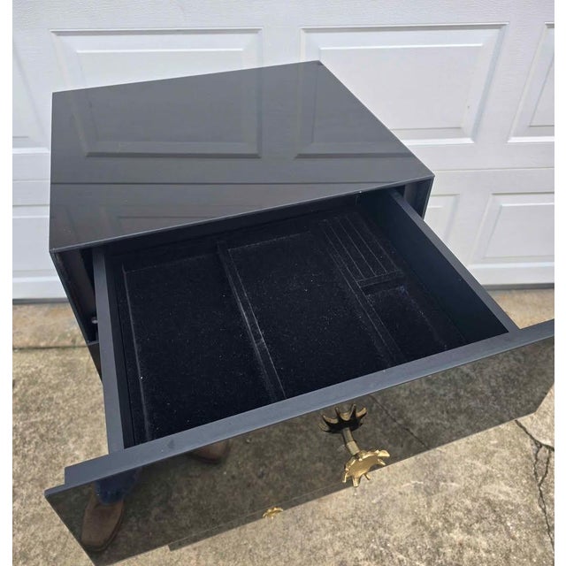 Description: This is a bold, high-impact tall chest finished in a deep, high-gloss black with striking starburst drawer...