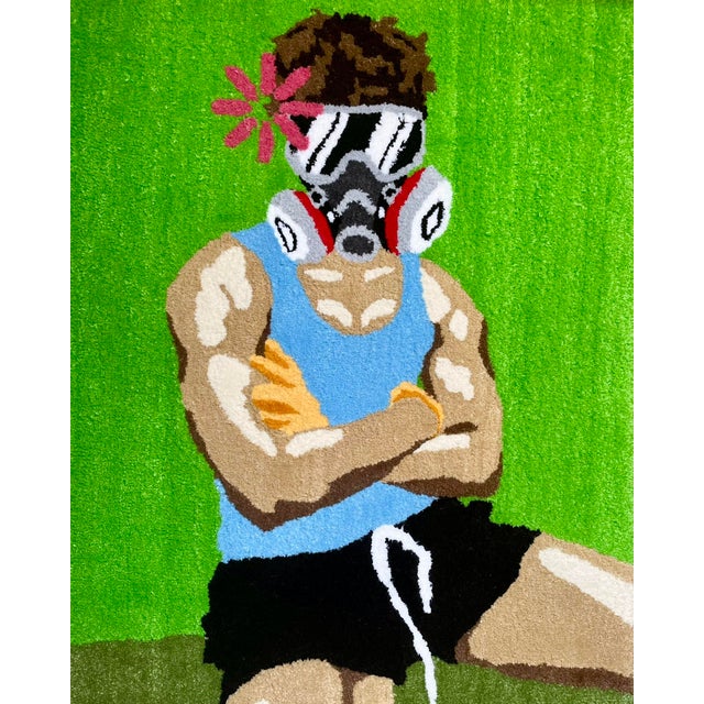A figure stands with arms crossed, a gas mask in place and a single red flower positioned at the head, all set against a...