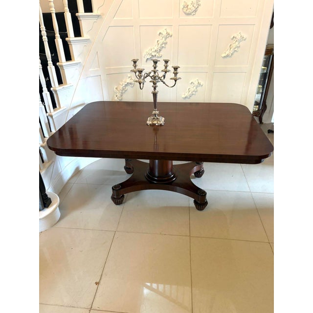 An antique William IV English figured mahogany pedestal dining table of exceptional quality featuring a solid tilt top and...