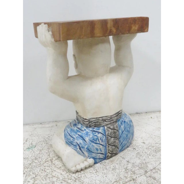 Carved painted Asian figure holding wood block.