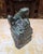 A vintage-style bronze frog sits atop a rock, sculpted in a naturalistic style to resemble either a bullfrog or pond frog...