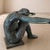 A rare French sculptural coffee table from the 1950s, crafted from cast bronze with a glass top. The base depicts a seated...