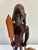 A vintage hand-carved wooden Maasai warrior sculpture featuring a traditional spear and shield. This artisan-crafted...