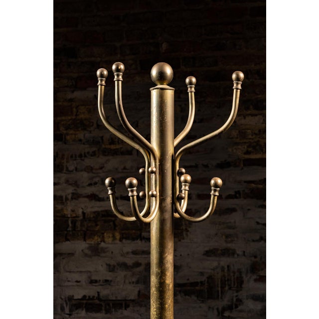 This antique brass 12-hook coat rack likely originated in the 1940s.